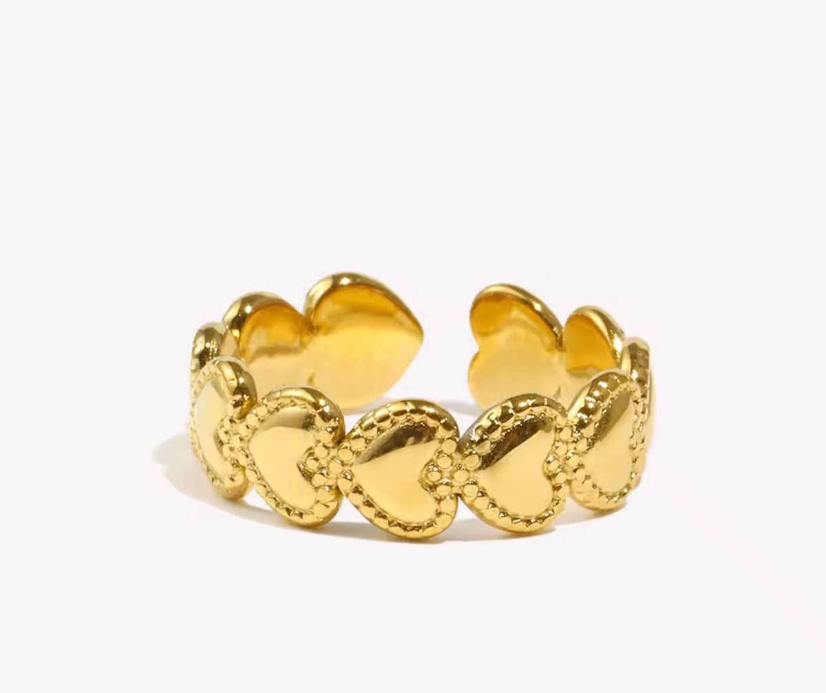 Anillo Amor dorado ajustable de acero inoxidable 316L con corazones y bordes de pequeñas bolitas.