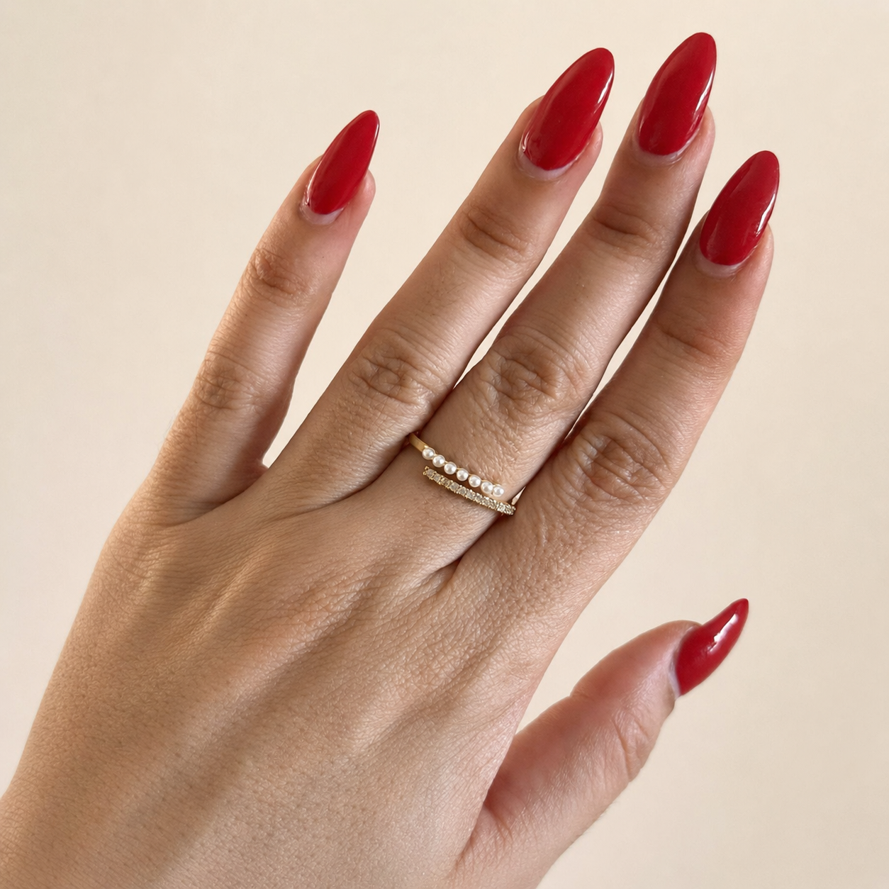 Anillo de chapa de oro 18K con zirconias, perlas y detalles dorados, diseño elegante para venta de joyería de mayoreo.