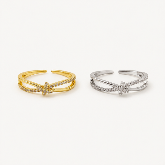 Anillo Nudo dorado con diseño entrelazado y detalles de cristales brillantes.