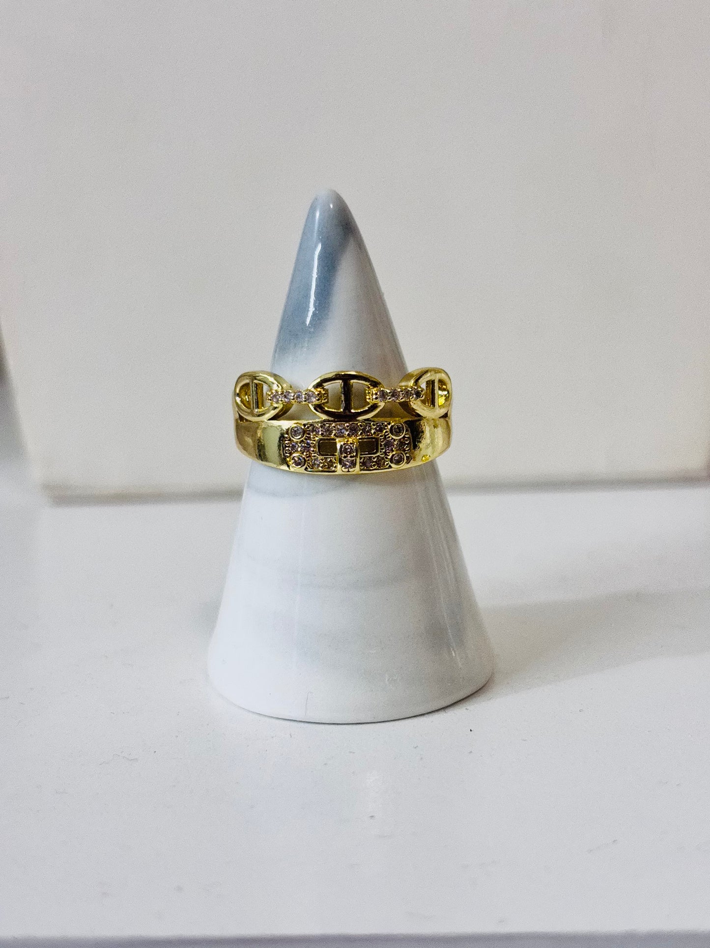Anillo con piedras decorativas y detalles dorados en acero inoxidable 316L, diseño elegante y brillante para joyería de mayoreo.