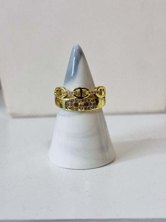 Anillo con piedras decorativas y detalles dorados en acero inoxidable 316L, diseño elegante y brillante para joyería de mayoreo.