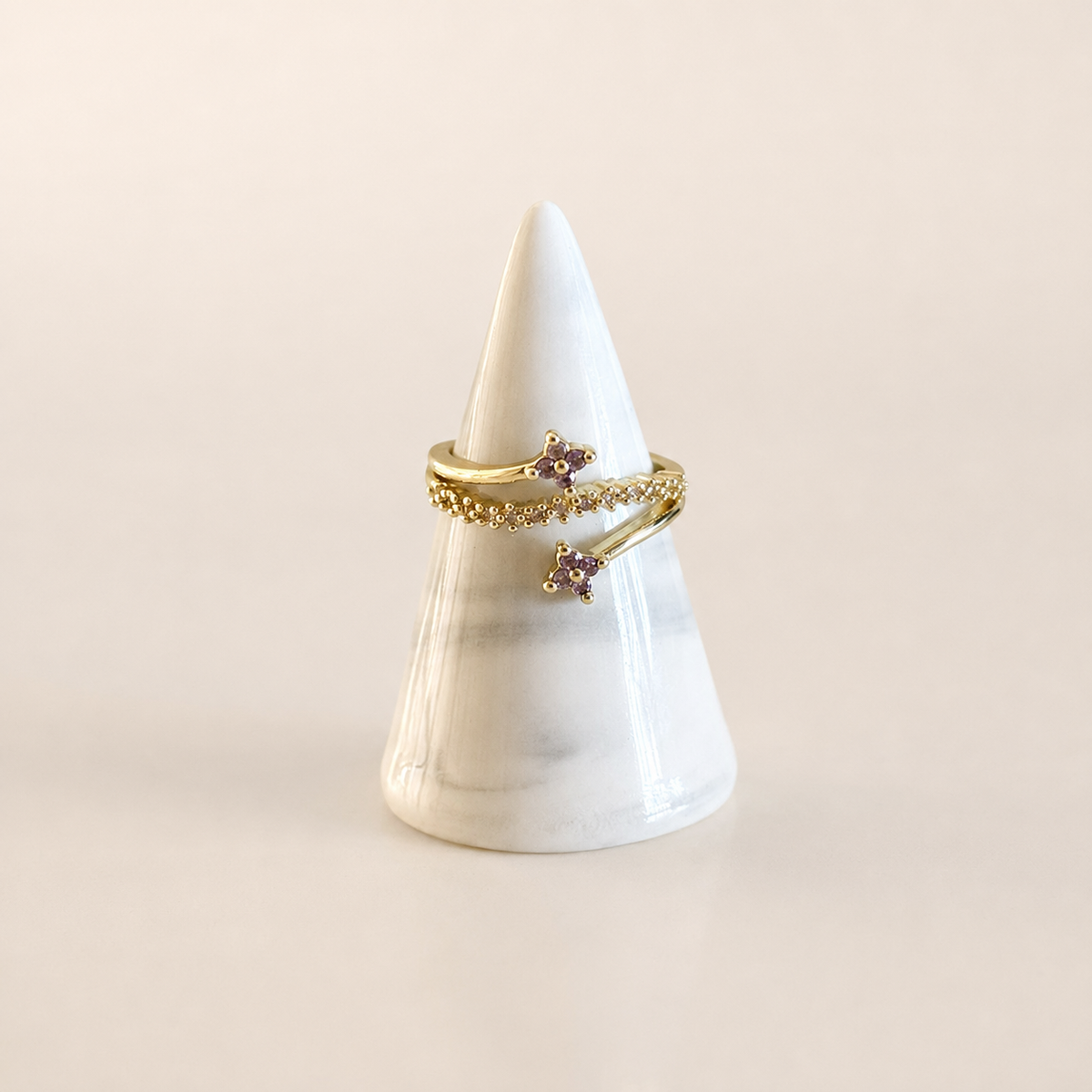 Anillo con zirconias moradas y detalles dorados, diseño elegante para venta de joyería de mayoreo.