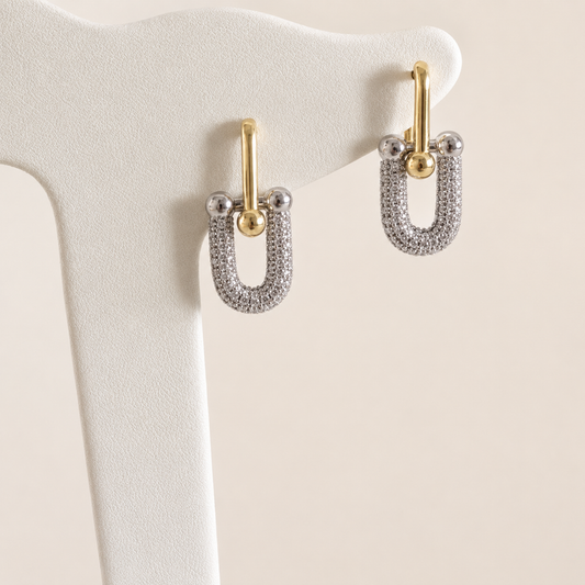 Arete Tiffany bicolor en chapa de oro de 18K. Diseño femenino, moderno y fácil de combinar para inventarios de joyería de mayoreo.