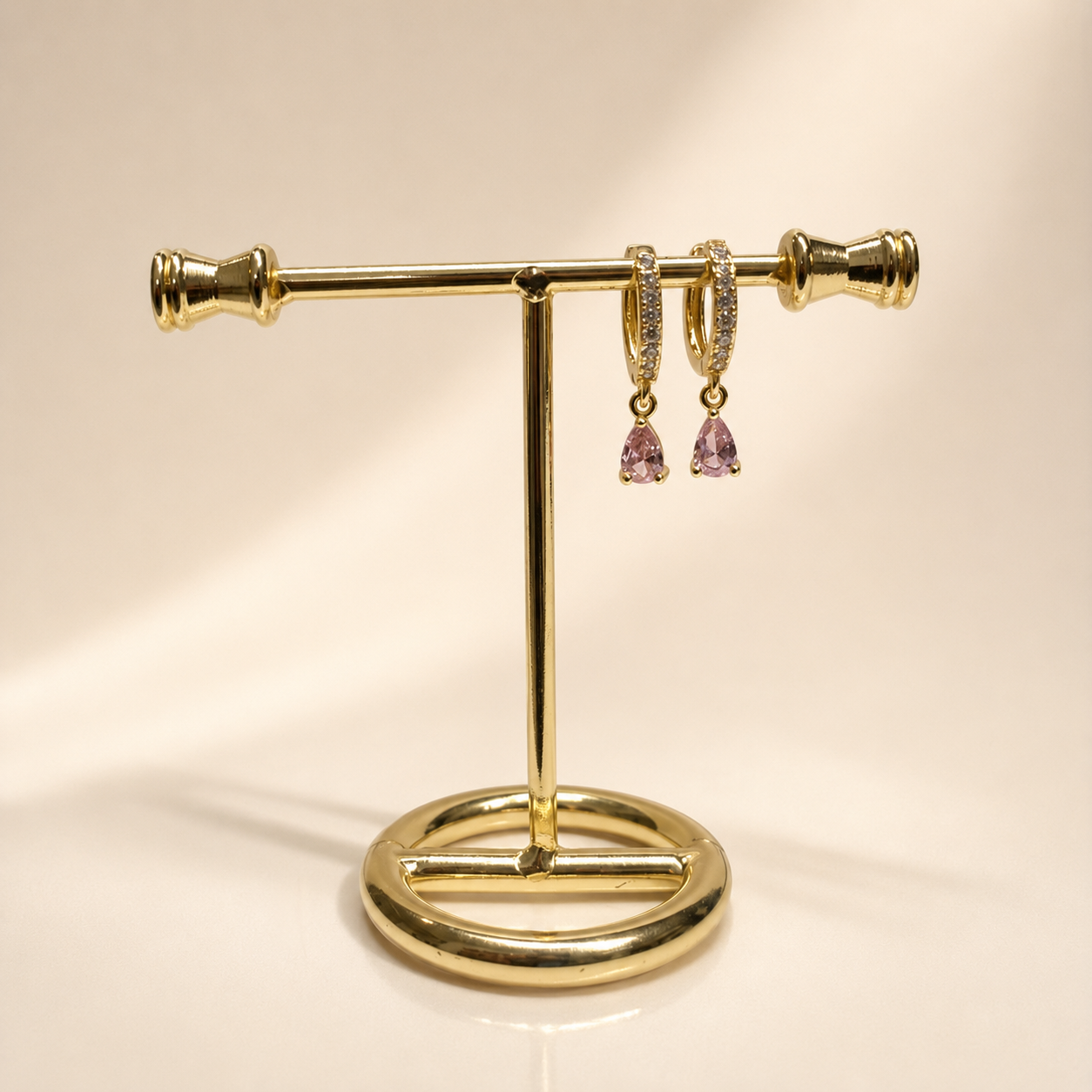 Huggies Mila Rose en chapa de oro de 18k con detalle de piedra rosa para venta de joyería al mayoreo.