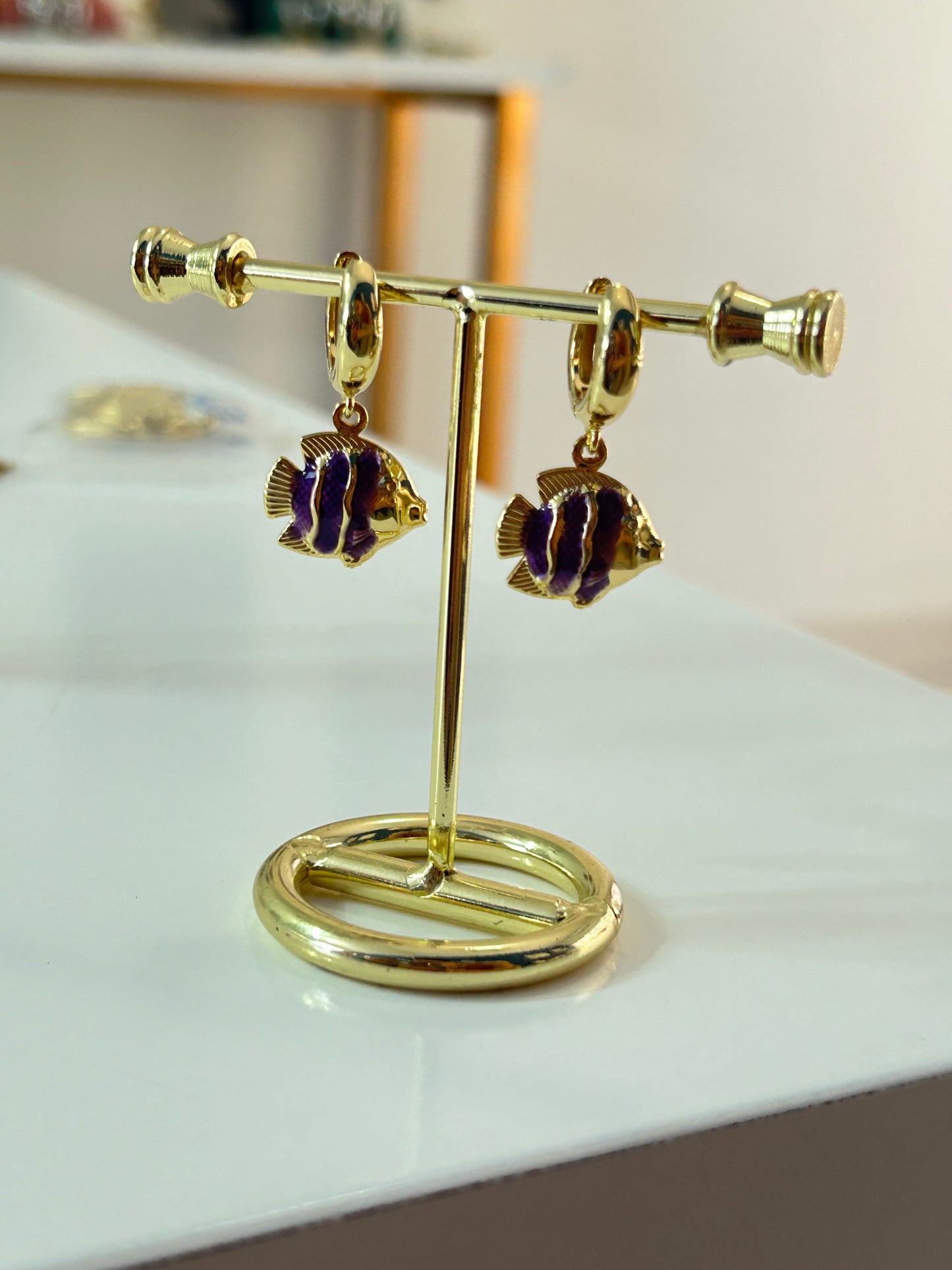 Huggies PEZ MORADO en chapa de oro 18K, aretes dorados con detalle juvenil para mayoreo.