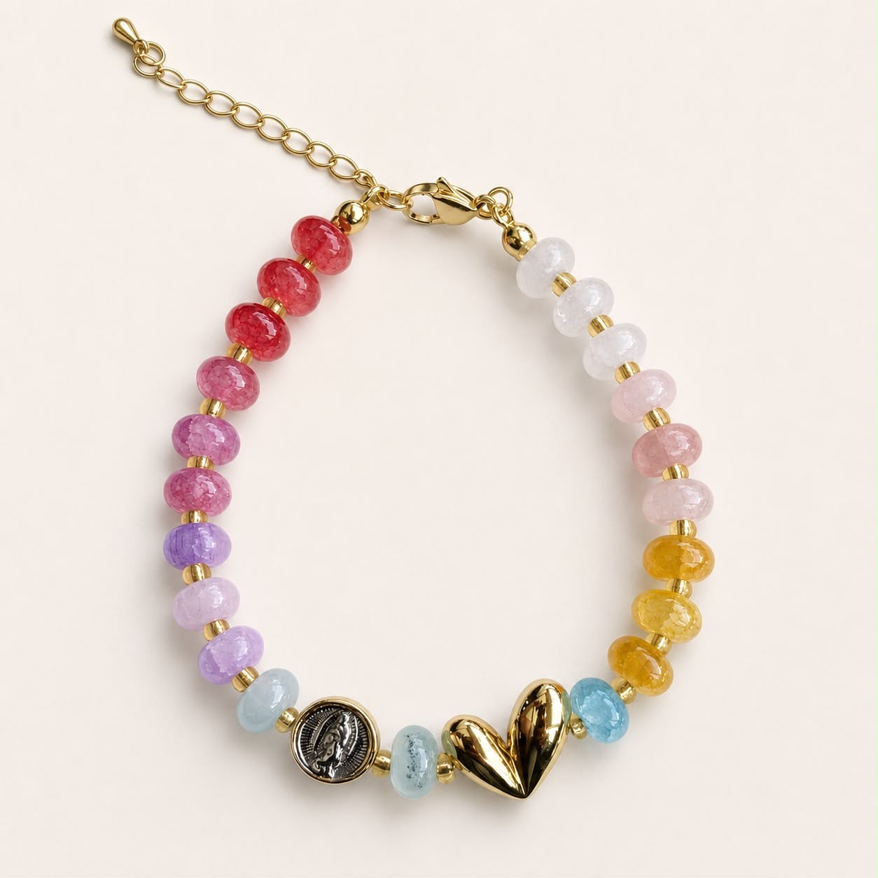 Pulsera religiosa con piedras de colores y detalles en chapa de oro 18K, de diseño delicado y femenino.