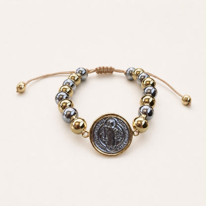 Pulsera religiosa con detalles en chapa de oro y símbolo de fe, diseño delicado para joyería de mayoreo.
