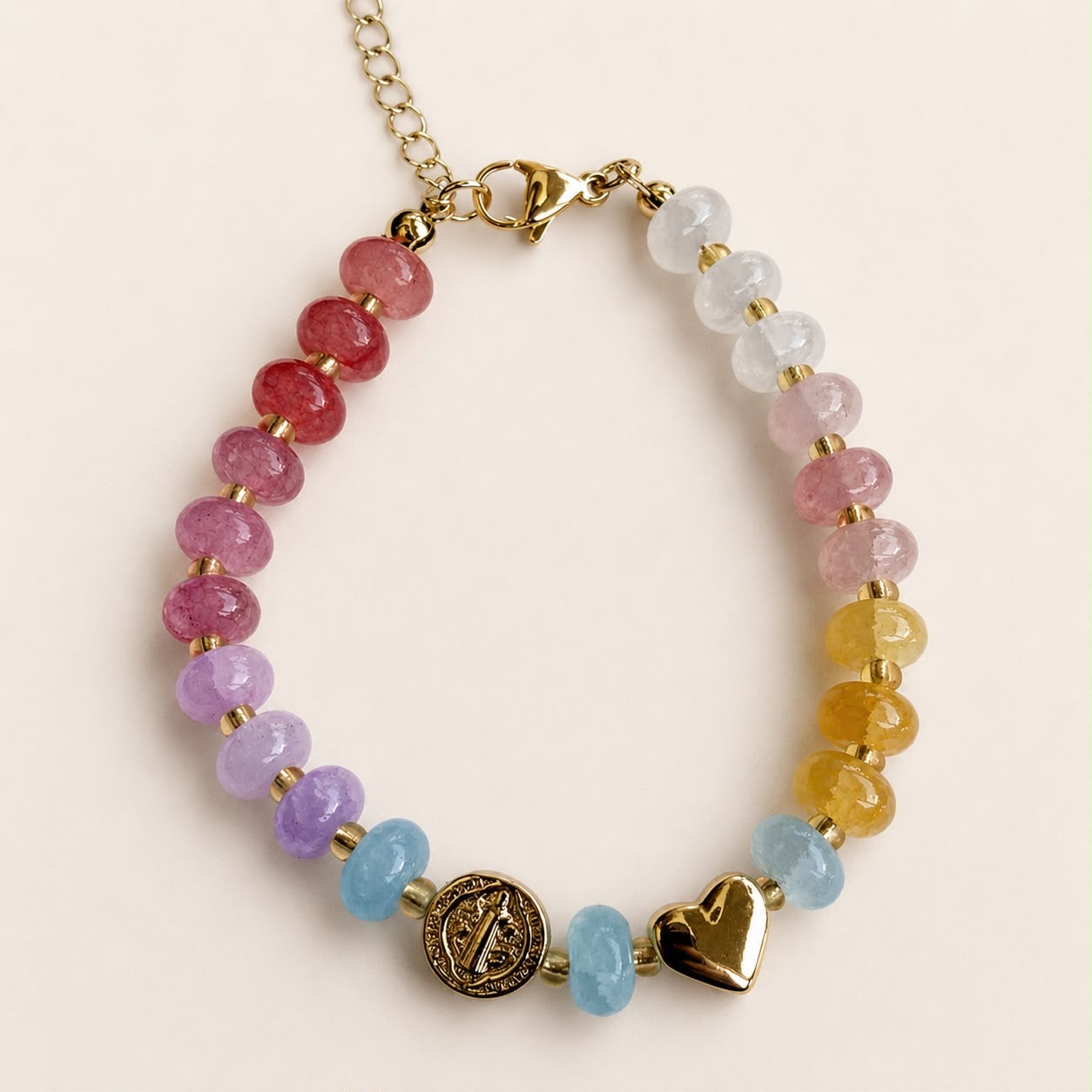 Pulsera religiosa con piedras de colores y detalles en chapa de oro 18K, de diseño delicado y femenino.