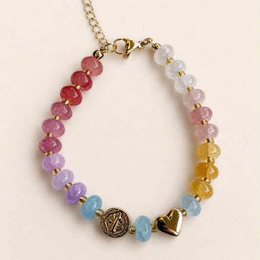Pulsera religiosa con piedras de colores y detalles en chapa de oro 18K, de diseño delicado y femenino.