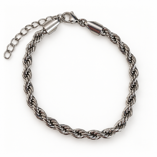     Pulsera color plata con diseño trenzado y acabado brillante. Una pieza moderna, versátil y fácil de integrar a cualquier inventario.