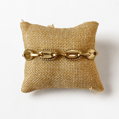 Pulsera Roma Link de acabado dorado con eslabones ovalados y detalles circulares decorativos.